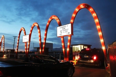 Cars parked facing the large outdoor screen at West Wind Las Vegas Drive-In