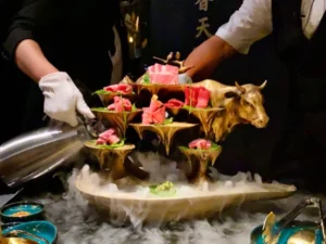 Golden bull meat presentation at X Pot Restaurant in The Venetian Las Vegas with cascading serving tiers fog effect and upscale dining experience