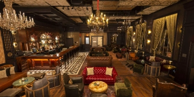 hidden speakeasy bar the barbershop at cosmopolitan las vegas with vintage decor plush seating and live music behind working barbershop