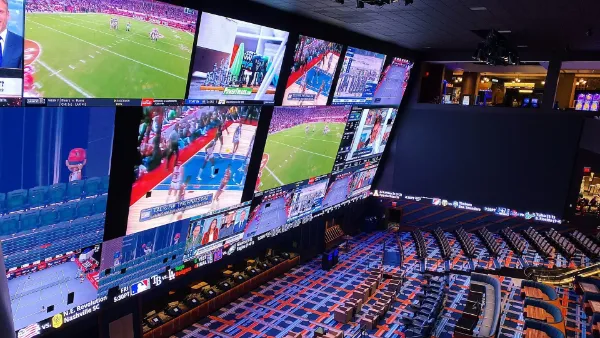 Interior of Circa Las Vegas sportsbook featuring a massive wall of high definition screens stadium style seating and live sports action