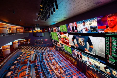 interior view of circa sportsbook in downtown las vegas with stadium seating and massive video wall showing live sports and betting odds