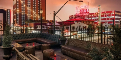 The lively rooftop patio at Commonwealth in Downtown Las Vegas with a crowd and views of Fremont Street