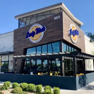 exterior of early birds breakfast restaurant in las vegas with wood paneling glass windows and outdoor seating under pergola