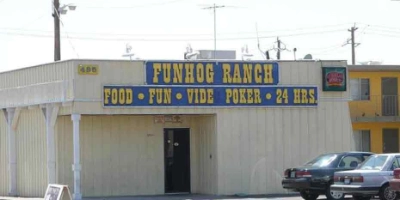 exterior of fun hog ranch gay bar in las vegas with 24-hour signage and video poker tavern entrance