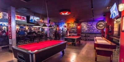 interior of the garage gay bar in las vegas with red pool tables video poker and neon-lit lounge decor
