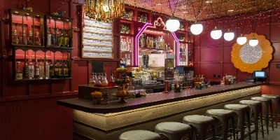 stylish interior of ghost donkey speakeasy in las vegas cosmopolitan with neon heart liquor shelves and festive bar decor