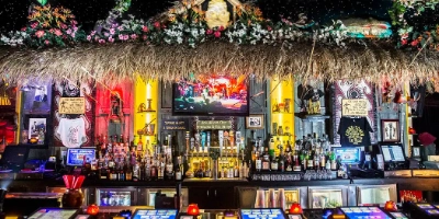 elaborately decorated golden tiki speakeasy in las vegas chinatown with tropical bar decor tribal masks and illuminated drink stations illustrating immersive nightlife experience