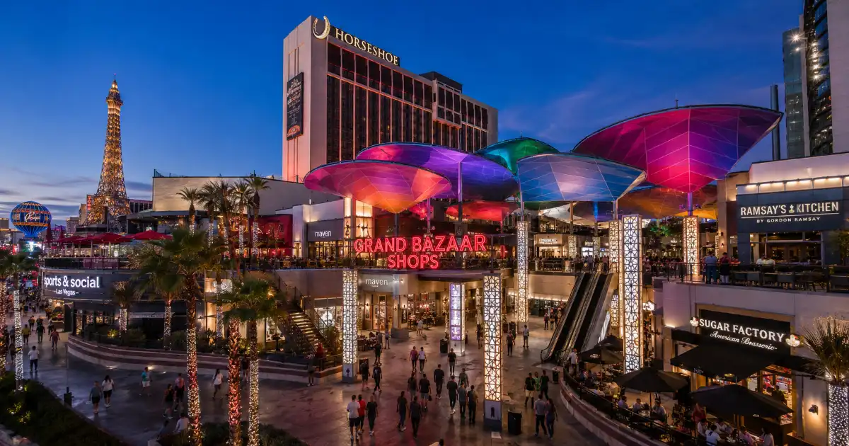 Visitors walk between compact storefronts and colorful canopy roofs inside the open-air Grand Bazaar Shops.