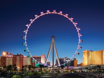 The High Roller Observation Wheel lit up at night over the Las Vegas Strip.