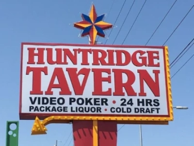 exterior of huntridge tavern dive bar in las vegas with colorful signage and 24 hour video poker and liquor