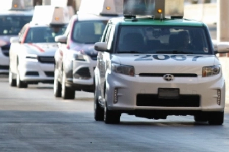 line of white las vegas taxicabs driving in single file at the taxi cab staging area