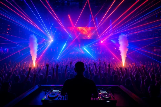 A DJs silhouette overlooking a massive packed dance floor at a Las Vegas nightclub filled with blue and red lasers