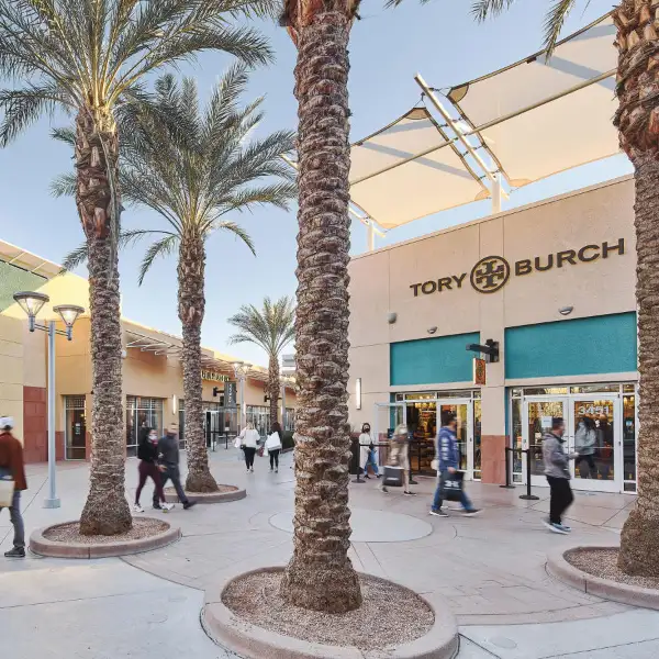 outdoor shopping scene at las vegas north premium outlets with tory burch storefront palm trees and modern architecture