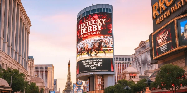 Las Vegas Strip at dusk with casino screens showing ads for the Kentucky Derby Watch Party