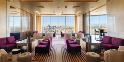 The sophisticated rooftop terrace of Legacy Club at Circa Resort with guests by the fire pits overlooking the Downtown Las Vegas skyline