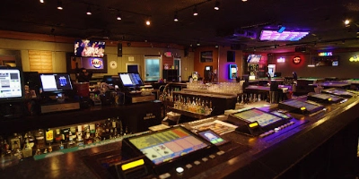 interior of quadz gay bar in las vegas with video poker machines built into bar counter and dim neon lit lounge atmosphere
