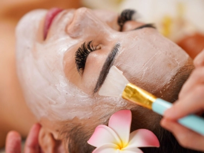 person receiving rejuvenating facial at las vegas spa with orchid flower and white mask application
