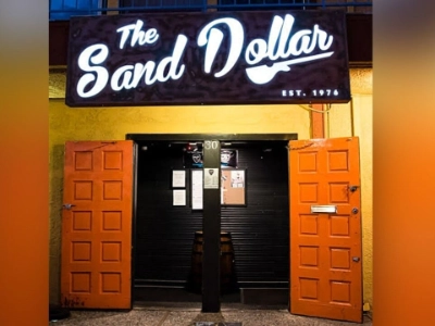 entrance of sand dollar lounge dive bar in las vegas with illuminated signage