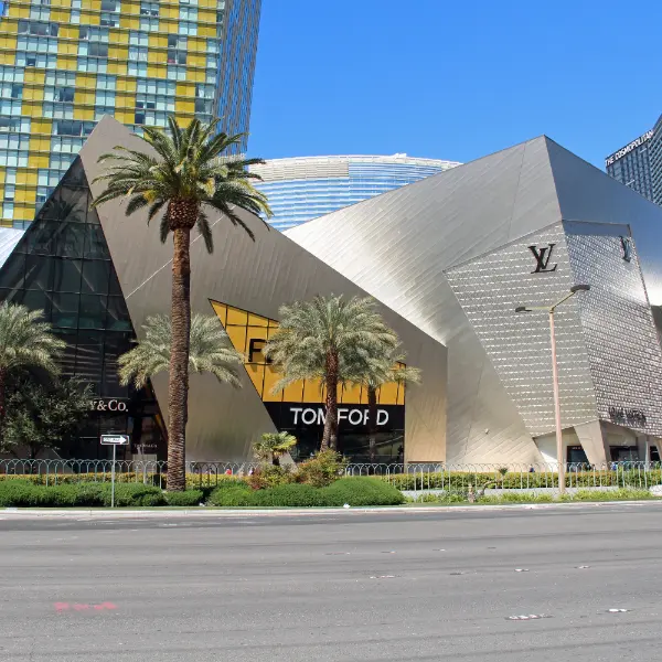 modern architectural exterior of the shops at crystals in las vegas with luxury brand signage palm trees and glass buildings