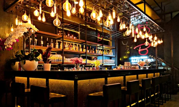 upscale las vegas bar with golden arch liquor display, green leather stools, and illuminated shelves