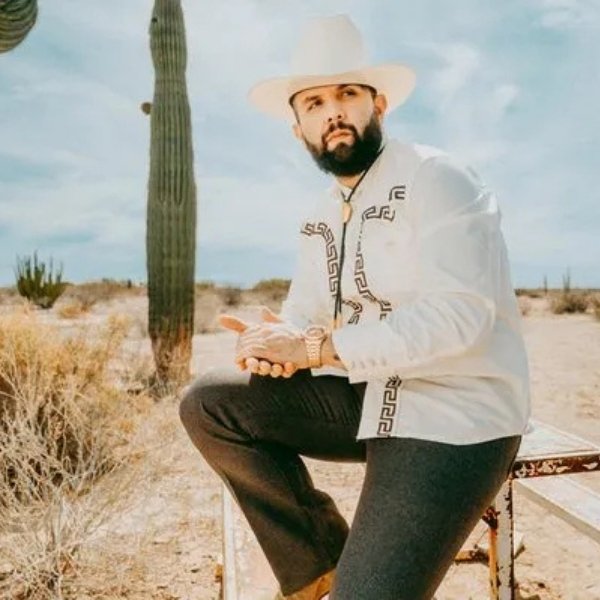 Carin Leon Image of Artist sitting on a stool with a desert background