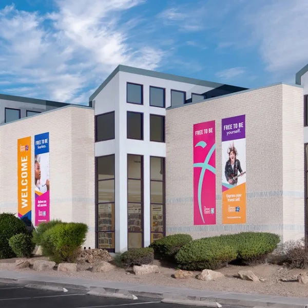 Exterior of West Charleston Library in Las Vegas with colorful banners promoting inclusivity and community engagement