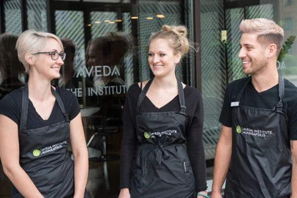 Aveda Institute Las Vegas entrance with students posing in front of the campus