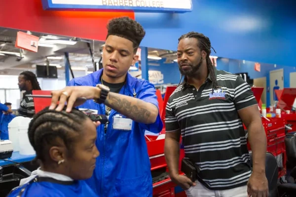 Barber students practicing haircutting techniques in a Las Vegas barber school training facility