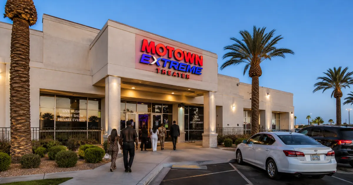 The signed entrance, glass doors, covered walkway, palm trees, and desert landscaping at Motown Extreme Theater in south Las Vegas.