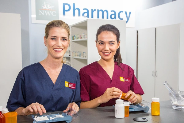 Students in scrubs training as pharmacy technicians at Nevada Career Institute in Las Vegas with prescription tools