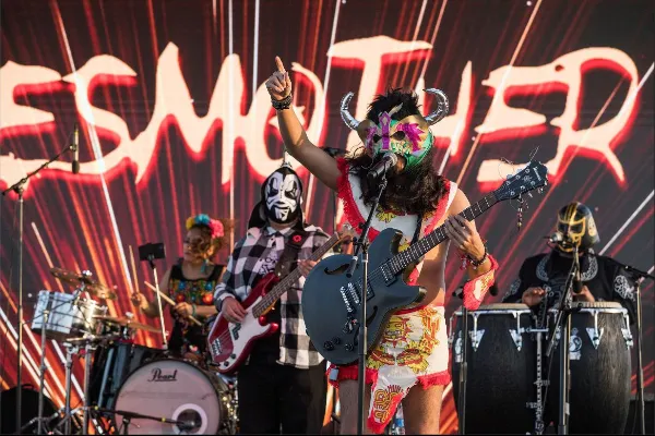 A live band performing in traditional cultural costumes at the Tacos and Tamales Festival stage