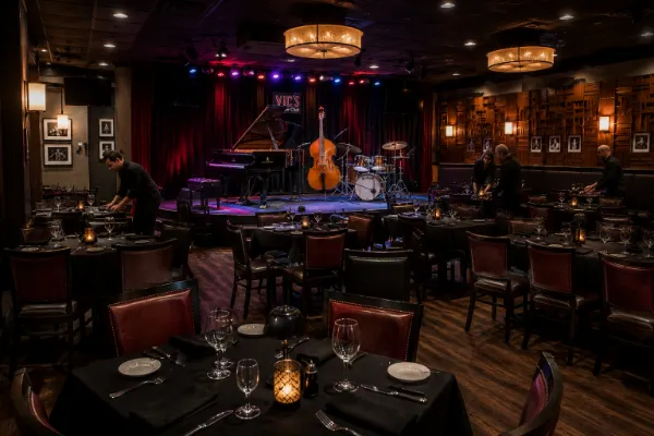 Dining tables face the piano, bass, drums, and permanent jazz stage inside Vic’s in Las Vegas.