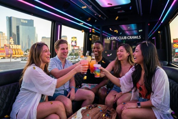 Guests toast with drinks on the party bus during an LA Epic Las Vegas Pool Crawl