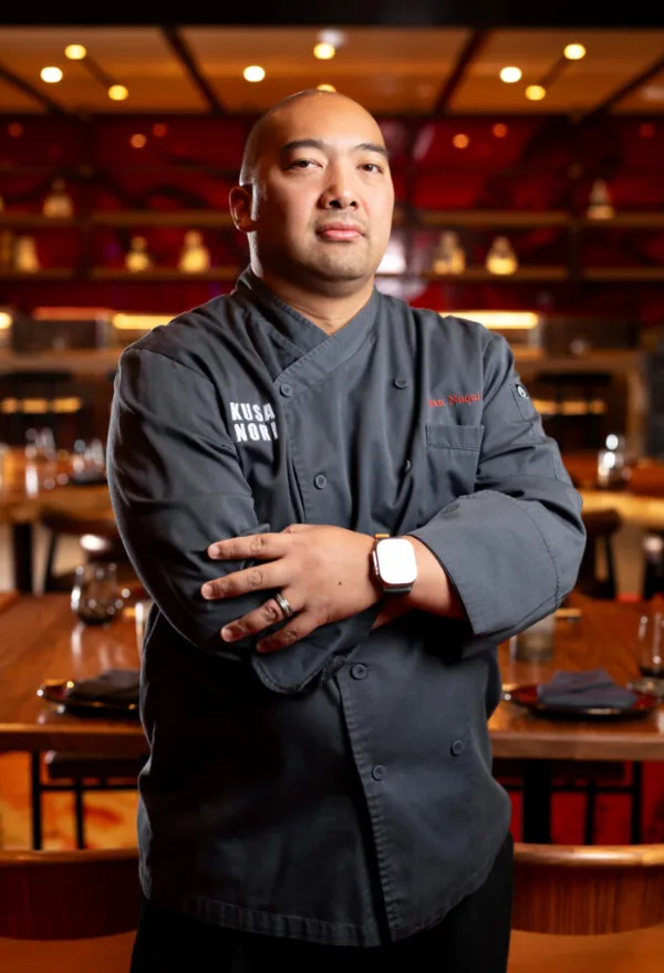 Executive Chef Ryan Nuqui posing in his white chef coat inside Kusa Nori at Resorts World Las Vegas