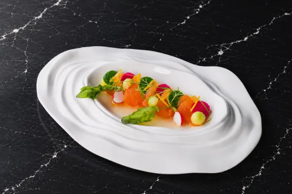 A beautifully plated dish of Ikejime Scottish Salmon Sashimi featuring delicate yuzu nuances and microgreens