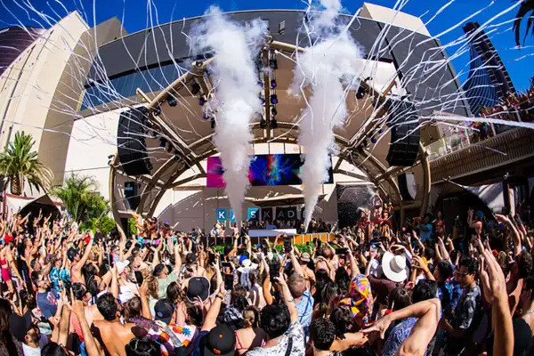 AYU Dayclub at Resorts World Las Vegas with pool party guests tropical decor and DJ stage