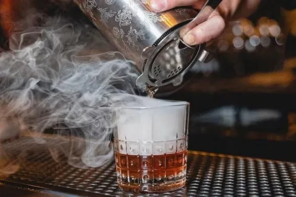 Smoky bourbon cocktail being prepared during a hands-on Las Vegas mixology class