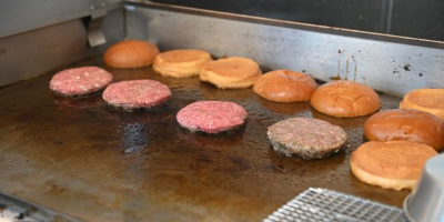 A photo of burgers and buns cooking on the grill at the Goodhood Burgers Food Truck in Las Vefas