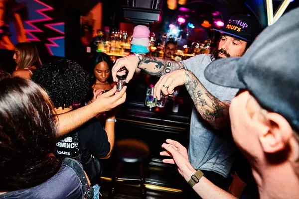 Turnt Up Tours Fremont Street Pub Crawl group walking between Downtown Las Vegas bars