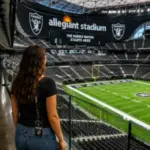 Visitor overlooking the Raiders field during a behind-the-scenes Allegiant Stadium Tour in Las Vegas, featuring the stadium interior and football field.