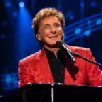 Barry Manilow sings into a microphone during a Las Vegas piano concert.