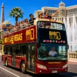 A red open-top Big Bus Tours Las Vegas double-decker bus carries sightseeing passengers past famous Las Vegas Strip landmarks on a guided city tour.