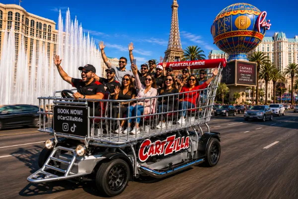 Guests waving from the open-air Cartzilla giant motorized shopping cart during a Las Vegas Strip sightseeing ride