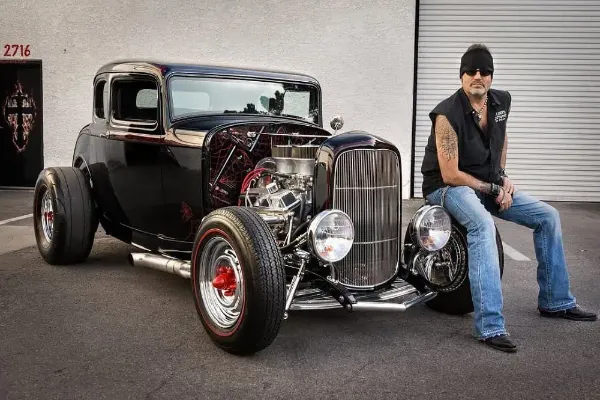 Danny Koker sitting on a customized classic car at Count’s Kustoms in Las Vegas