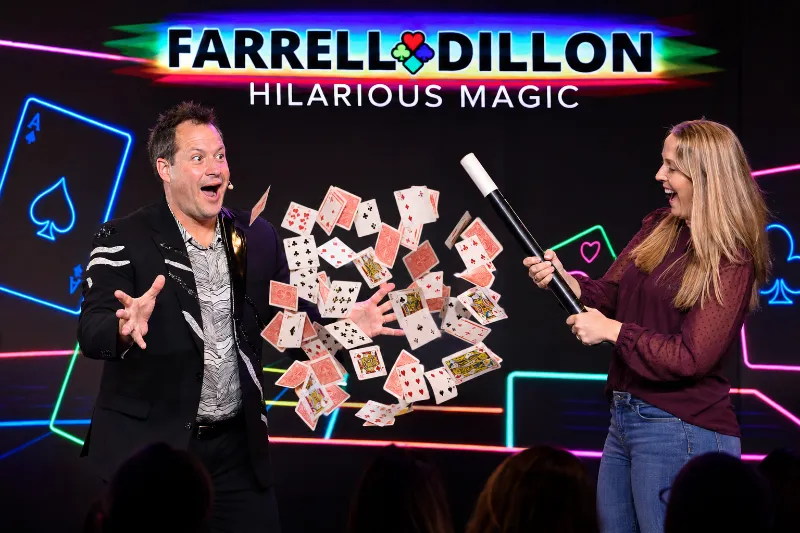 Farrell Dillon reacts as an audience volunteer creates a colorful playing-card surprise during his hilarious Las Vegas magic show.
