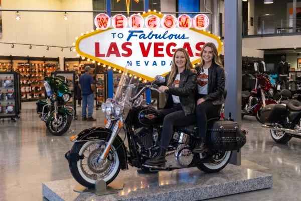 Visitor posing on a display motorcycle at Las Vegas Harley-Davidson