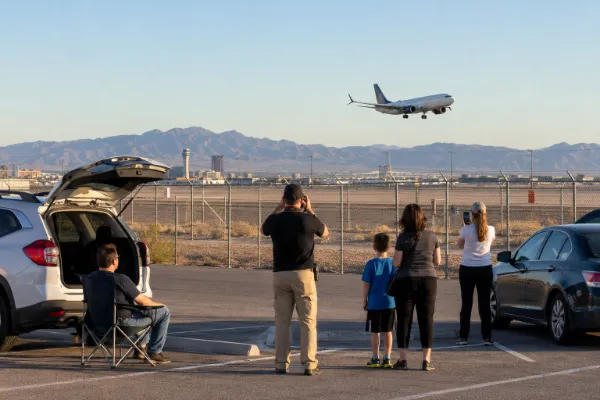 Aviation fans photograph a passenger jet from the public runway viewing lot beside Harry Reid International Airport in Las Vegas.