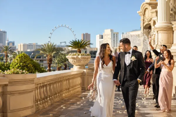 Newly married couple celebrating with friends at an elegant Las Vegas resort with the High Roller in the background.