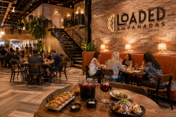 Brick walls, warm table lamps, wooden furnishings, and banquette seating define the dining room at Loaded Empanadas.
