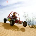 A dune buggy launches over a high sand dune during the Mini Baja Dune Buggy Chase in Las Vegas.